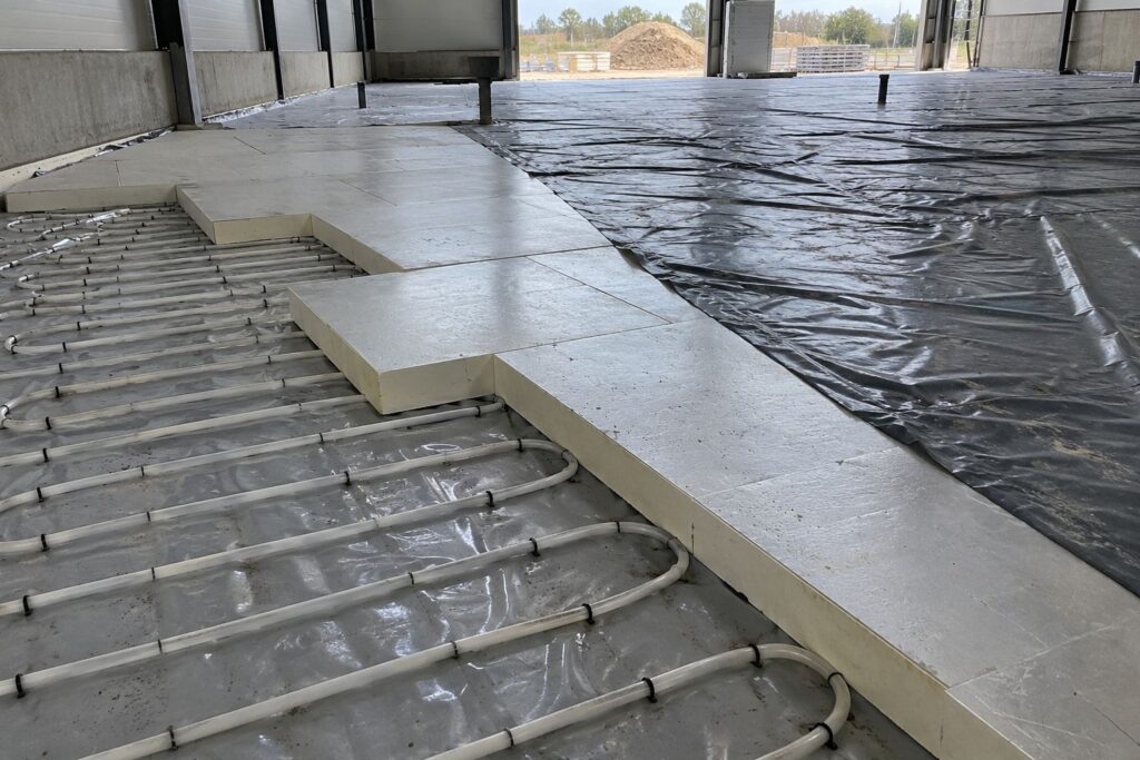 Vriescelvloer in aanbouw met isolatieplaten, folie en verwarmingsleidingen